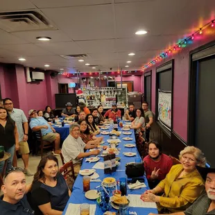 a large group of people sitting at a long table