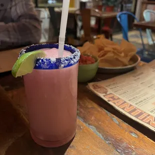 a drink with a straw and a lime garnish garnish