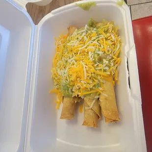Rolled tacos with cheese and guacamole.