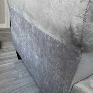 After repair, slightly different fabric color and texture. Fabric not following complete curve of sofa arm like before