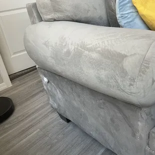Before repairs, fabric follows tightly around curve of sofa arm