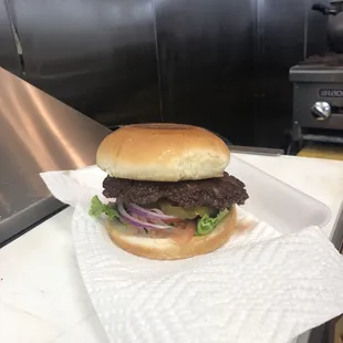 a hamburger on a bun with onions and lettuce