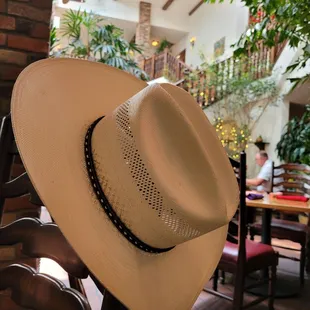 My cowboy hanging on a chair , While we're getting ready to have a great meal .
