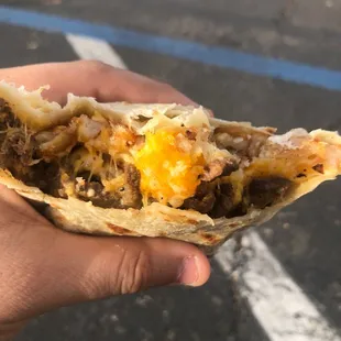 a hand holding a burrito