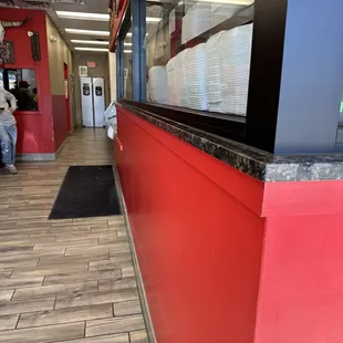 The food ordering counter/meat shop is along the right hand side. The left hand side has a handful of chairs.