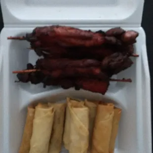 Chicken on a.stick and spring rolls.