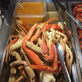a tray of crab legs and crab legs with dipping sauce