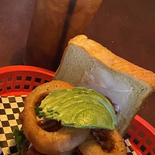 a sandwich with avocado and onion rings