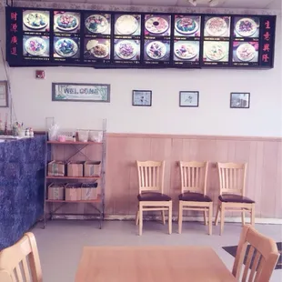 a restaurant with a large menu on the wall