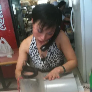 a woman sitting at a table with a phone to her ear