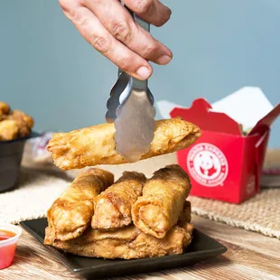a person holding a knife over a plate of fried food