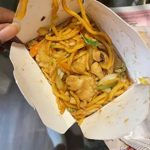 a person holding a box of noodles