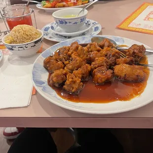 General Tso Chicken with Vegetable Fried Rice In the back it&apos;s sweet and sour chicken.