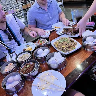 a group of people sitting at a table with food