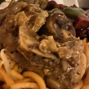 a plate of noodles with meat and vegetables