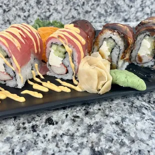 a variety of sushi on a black plate