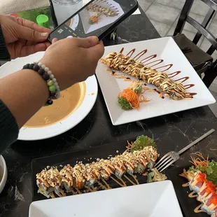a person taking a picture of a plate of food