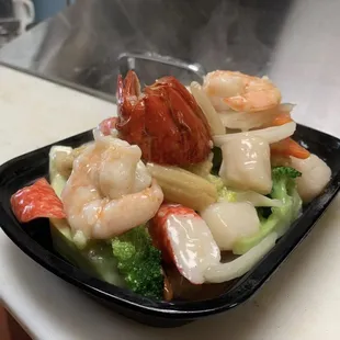 a plate of shrimp, broccoli, and carrots