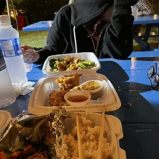 a man in a hoodie sitting at a picnic table