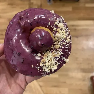a hand holding a purple donut