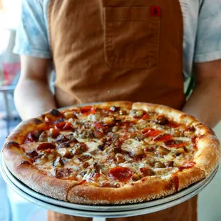 a man holding a pizza
