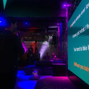 a man standing in front of a large screen