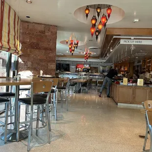 Panevino Deli counter with food, high top and regular table seating.