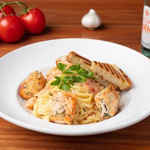 Salmon Scampi Linguine: Creamy scampi sauce with grilled salmon, garlic, tomatoes, capers, and parmesan.