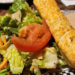 a plate of food with a sandwich and salad