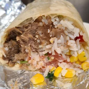 Grilled steak burrito with white cilantro rice, refried beans, and other topings