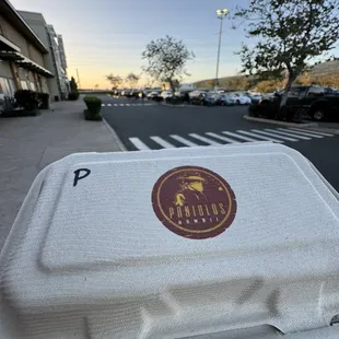 a styrofoam container on a sidewalk
