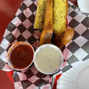 a basket of breadsticks and dipping sauce