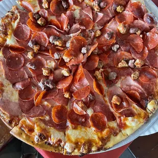 a pepperoni pizza on a paper plate