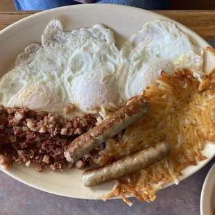 Corned beef hash, eggs over easy, hash browns, and sausage