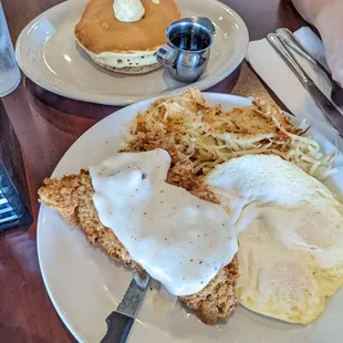 Chicken fried steak with hash brown and pancakes.