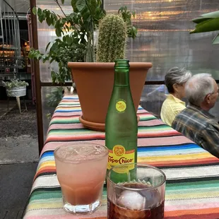 a bottle of soda and a glass of ice