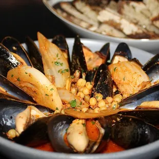 The Cozze are bangs island mussels served in saffron-tomato brodo, n&apos;duja, braised fennel, &amp; fregola with a side of grilled bread.