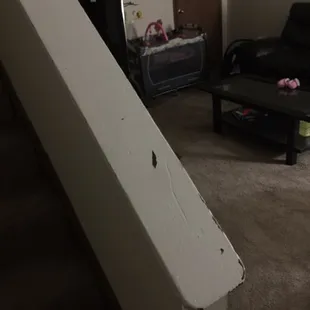 A wood banister painted white and its coming off...