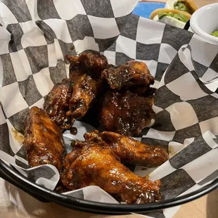 a basket of chicken wings with a side of broccoli