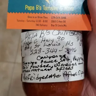 a hand holding a jar of sauce