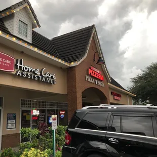 a car parked in front of a pizza parlor