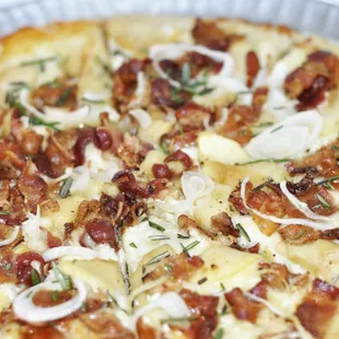 a pizza with onions and bacon