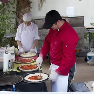 two men making pizzas