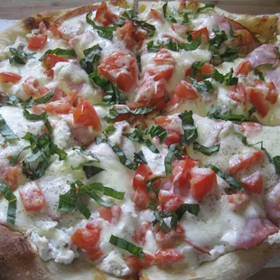 The &apos;Sir Charles&quot; white pizza with Ricotta, sausage, garlic, ham, tomato&apos;s, basil and fresh cracked pepper.