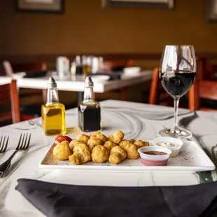 a plate of appetizers and a glass of wine