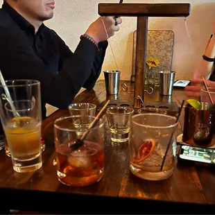 a man sitting at a table with drinks