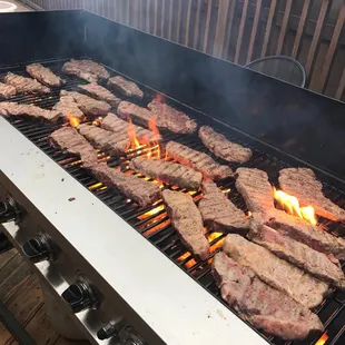 steaks cooking on the grill