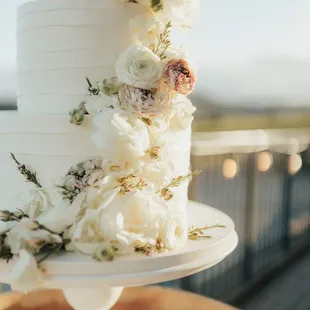 a white wedding cake with fresh flowers