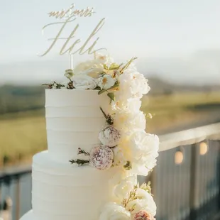 a white wedding cake with fresh flowers