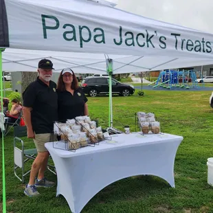 a man and woman standing under a tent